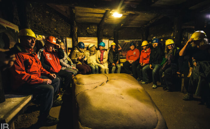 Visitors seated around the Megalith K-2 stone inside the Ravne Tunnels near the Bosnian Pyramid complex.