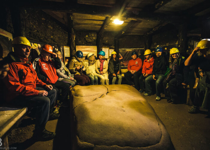 Visitors seated around the Megalith K-2 stone inside the Ravne Tunnels near the Bosnian Pyramid complex.