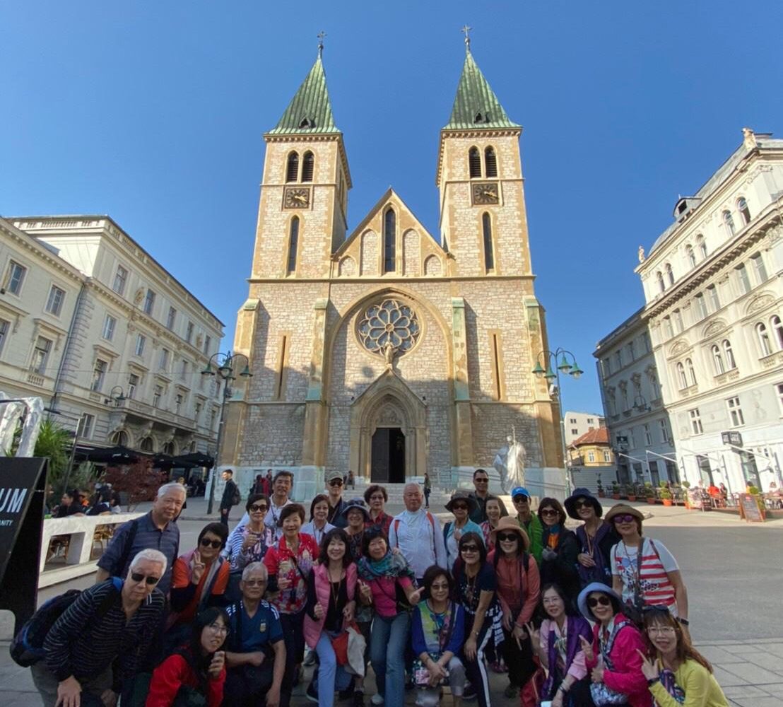 Group of tourists posing in front of Sarajevo Cathedral during a Free Walking Tour