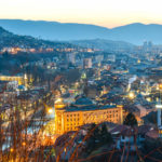 Night view of Sarajevo with city lights and surrounding mountains
