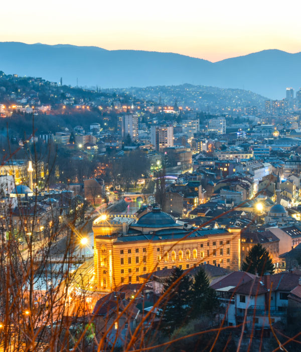 Night view of Sarajevo with city lights and surrounding mountains
