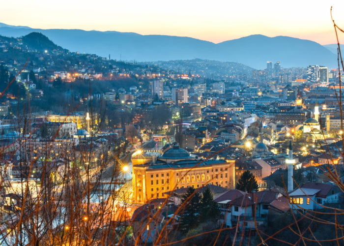 Night view of Sarajevo with city lights and surrounding mountains