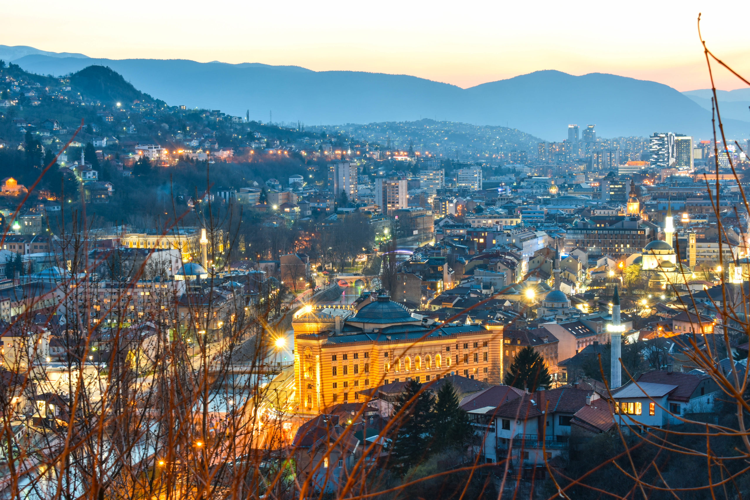 Night view of Sarajevo with city lights and surrounding mountains