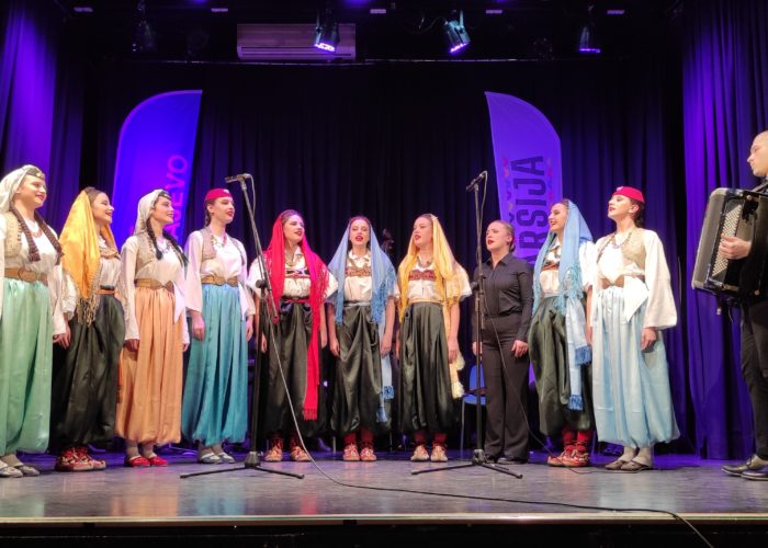 Traditional Bosnian women performing in colorful attire at a cultural event.