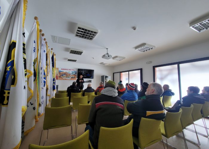 Group education session with flags in the background.