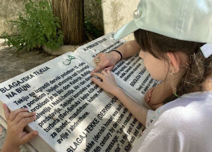 Children reading a signboard at Blagaj Tekke, a historic Dervish monastery in Bosnia and Herzegovina.