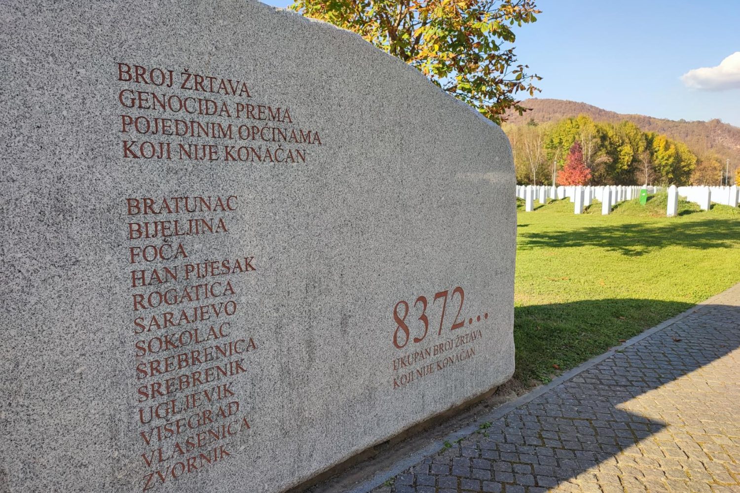 Memorial stone at Srebrenica with the inscription of towns affected by the genocide and the number 8372 representing the total victims.